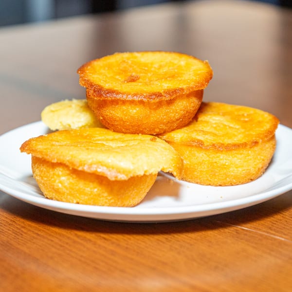 Golden-brown Caribbean cornmeal fritters, called Johnny Cakes, on a white plate at Bullfish Bistro.